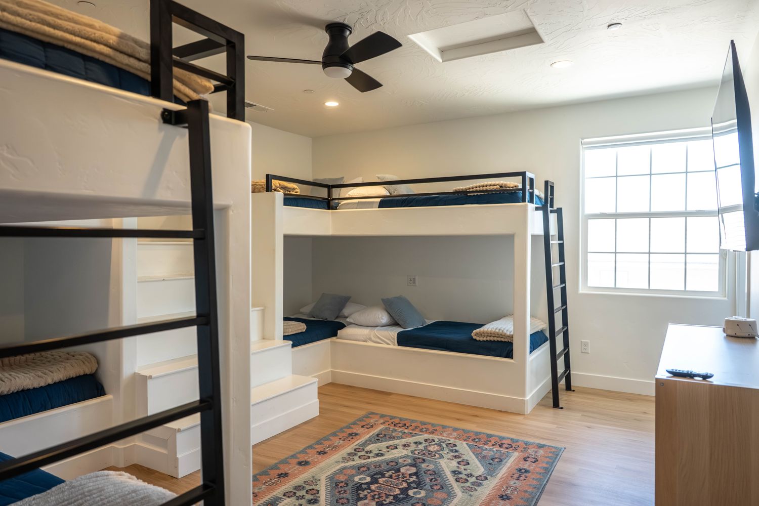 Bunk room with navy bedding and a rug