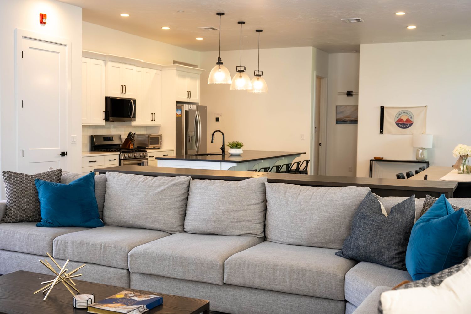 Living room with a large gray sectional, open to the kitchen